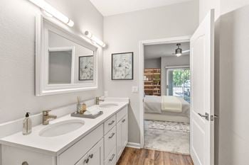A white bathroom with a vanity and a mirror